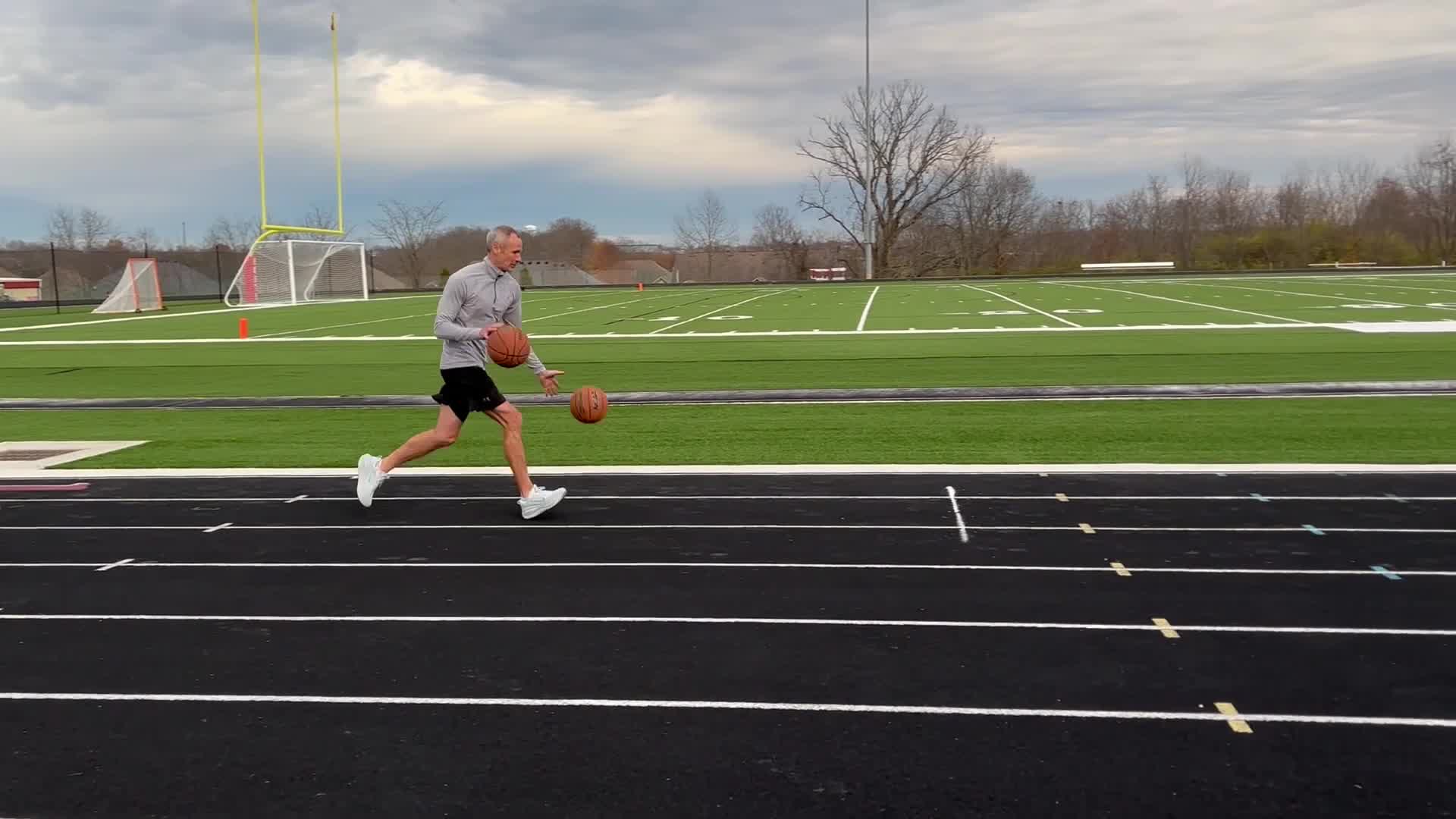 Video thumbnail for Fastest mile dribbling two basketballs