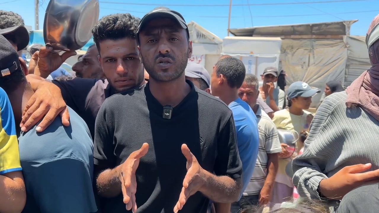 Video thumbnail for Displaced Palestinians queue for charity food distribution in Gaza.