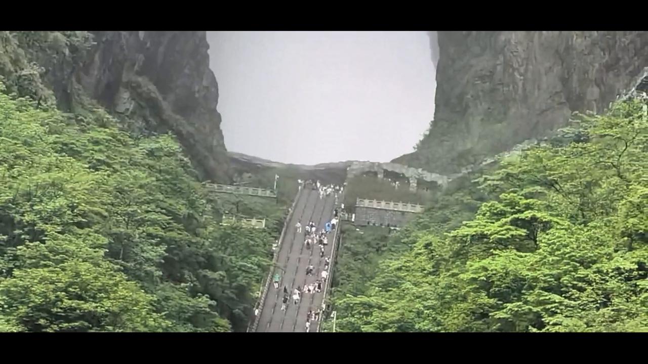 Video thumbnail for China: Chinese Tourists Film Rocks Falling Behind Tianmen Cave in China.
