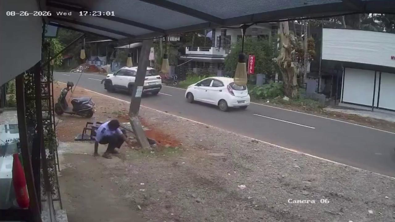 Video thumbnail for India: Security guard narrowly avoids impact as car loses control outside hotel, crashes into electric pole.