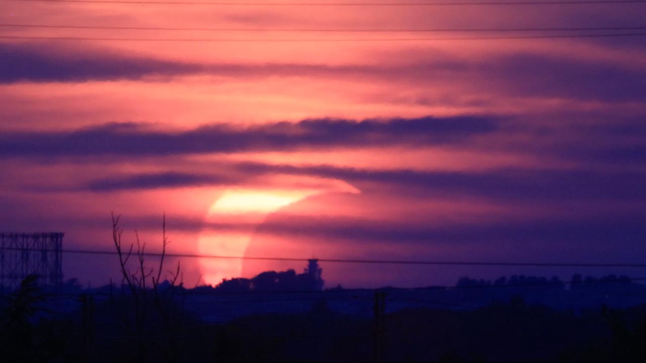 Video thumbnail for Italy: Partial solar eclipse at sunset over Rome skyline with Gasometer silhouette..