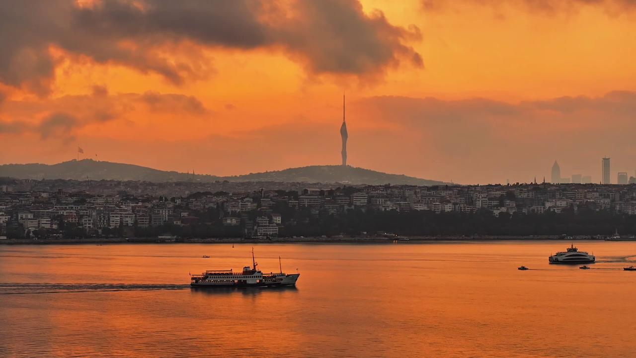 Video thumbnail for Türkiye: Sunrise paints Istanbul’s Bosphorus, Maiden’s Tower in orange hues.