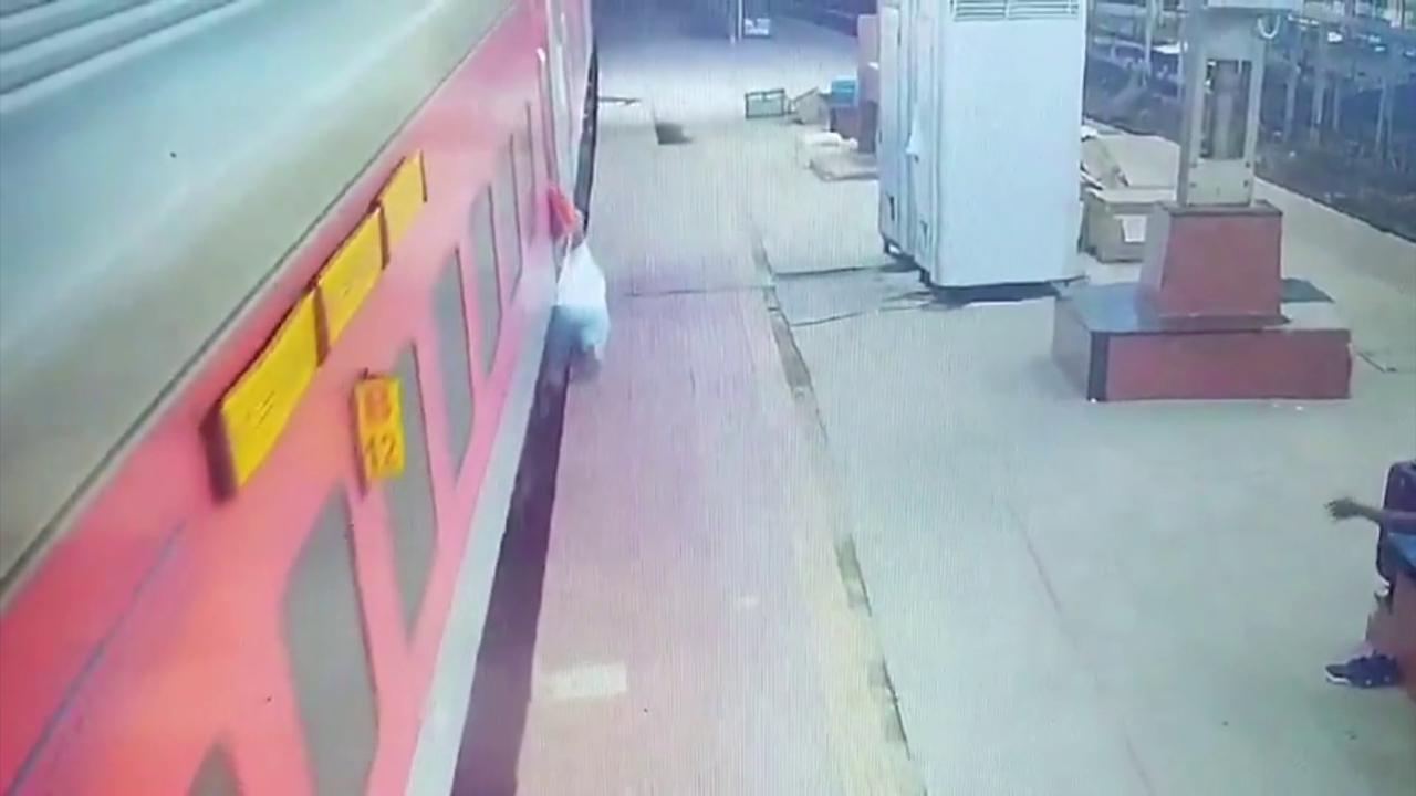 Video thumbnail for India: Quick-thinking official saves passenger as slip sends him beneath moving train during boarding.
