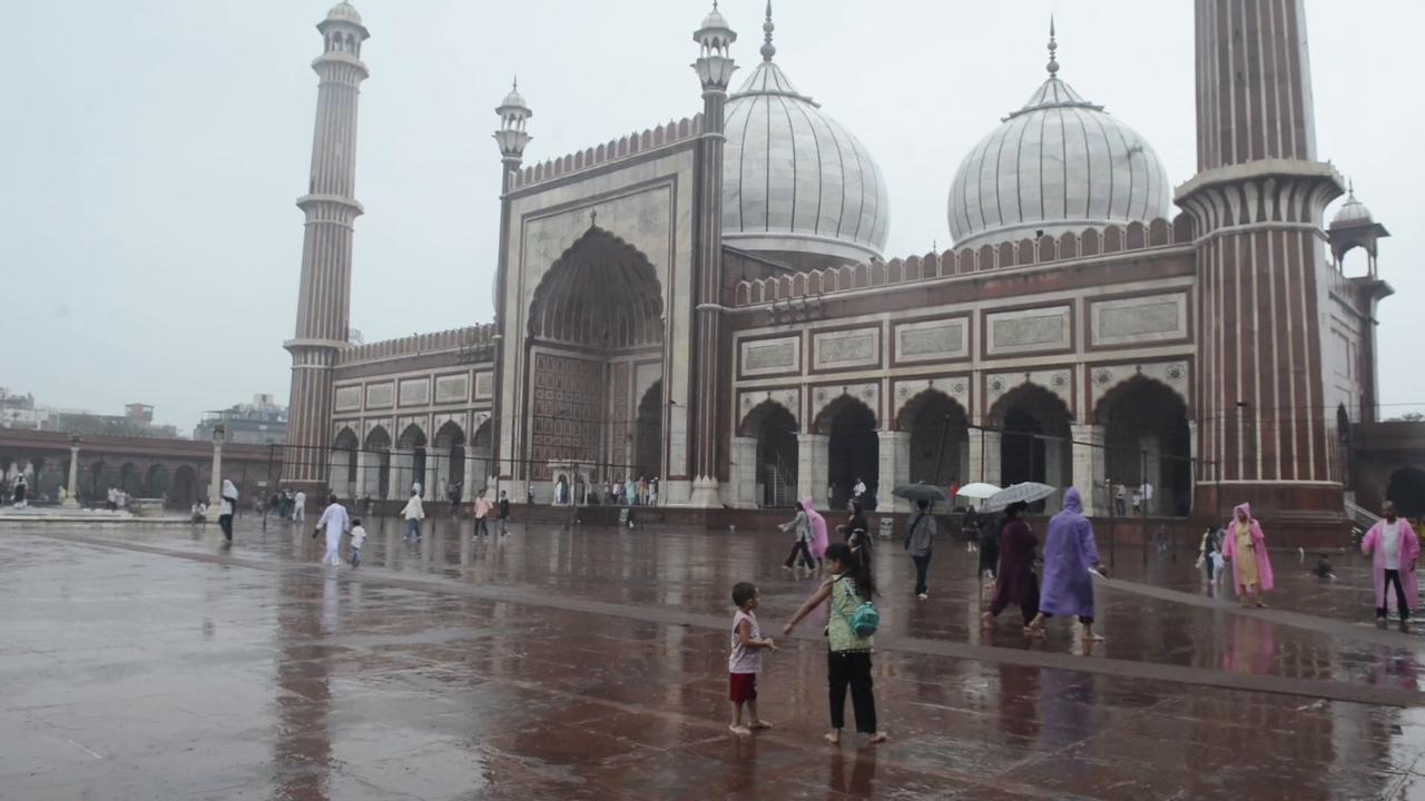 Video thumbnail for India: Heavy rain lashes New Delhi as visitors crowd historic Jama Masjid.