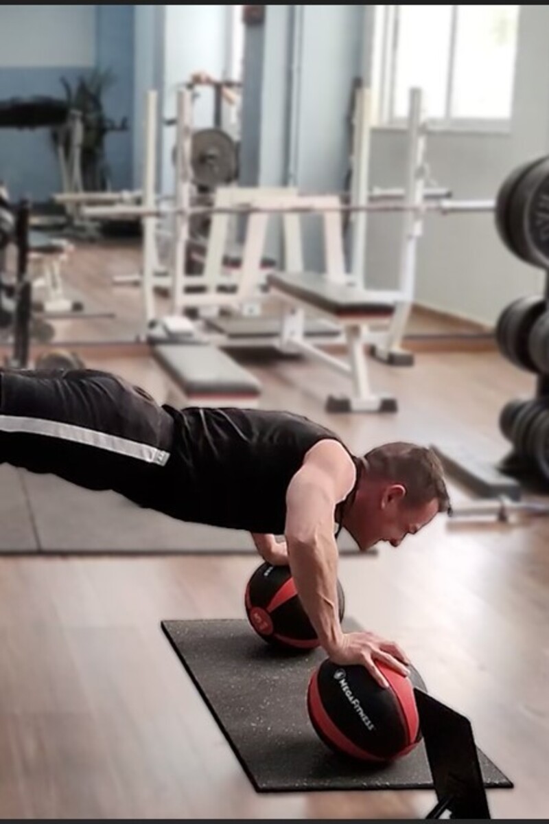 Video thumbnail for Most decline push ups on medicine balls in one minute (male)  79 by George Kotsimpos