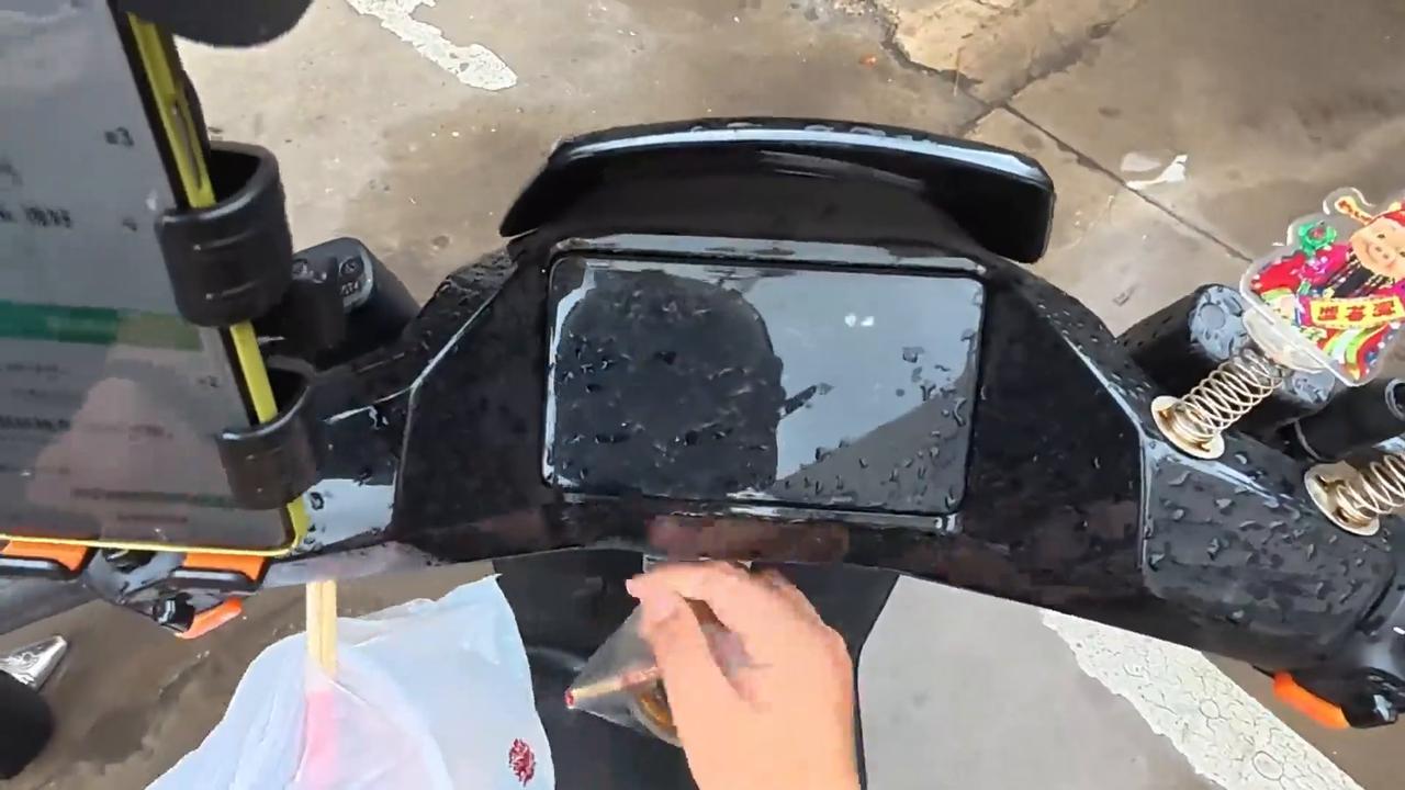 Video thumbnail for China: Chinese deliveryman rescues rain-soaked cat found under electric scooter.
