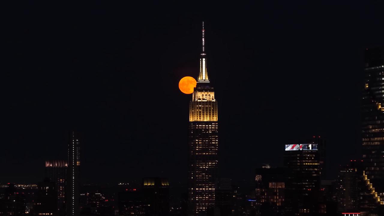 Video thumbnail for US: Strawberry Moon rises behind Manhattan skyline in New York City.