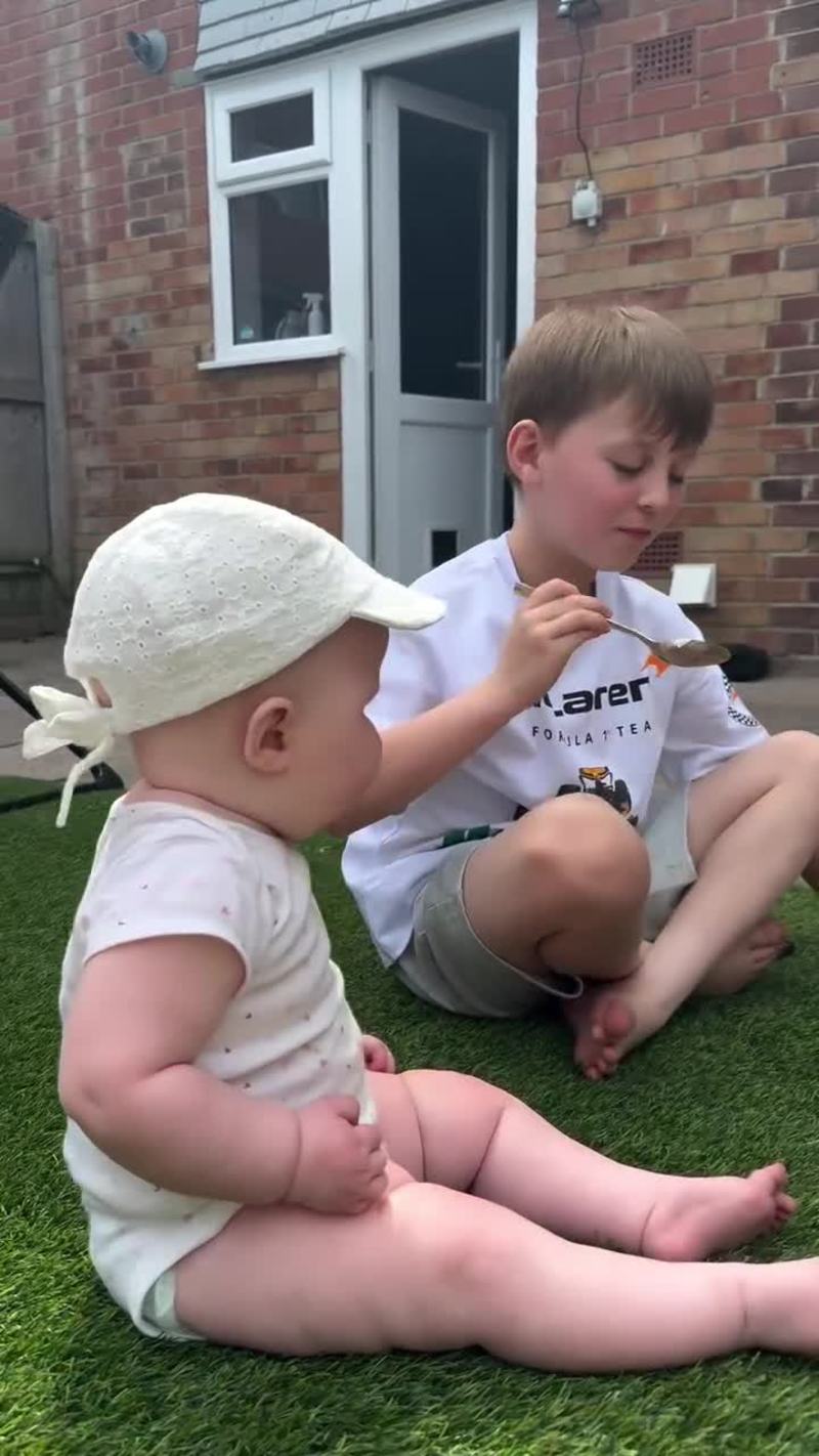 Video thumbnail for Big Brother Sharing Ice Cream with Baby Sister on the Lawn