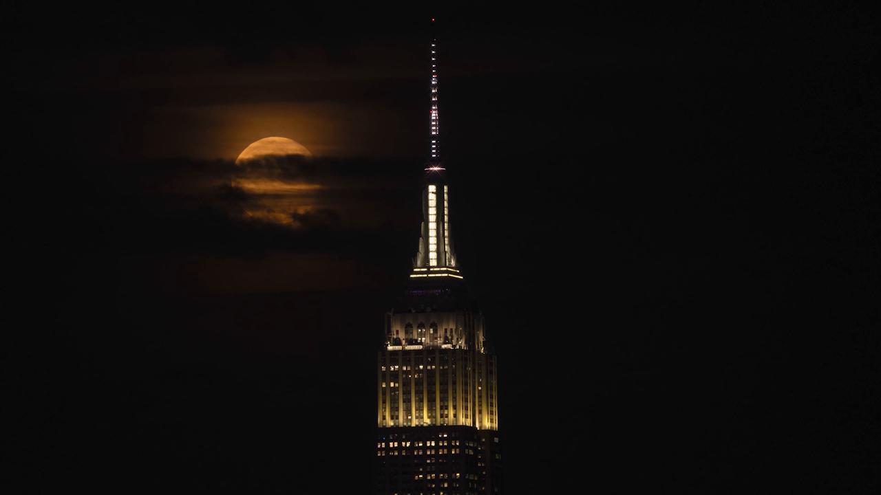 Video thumbnail for US: Full moon rises behind Empire State Building in New York.