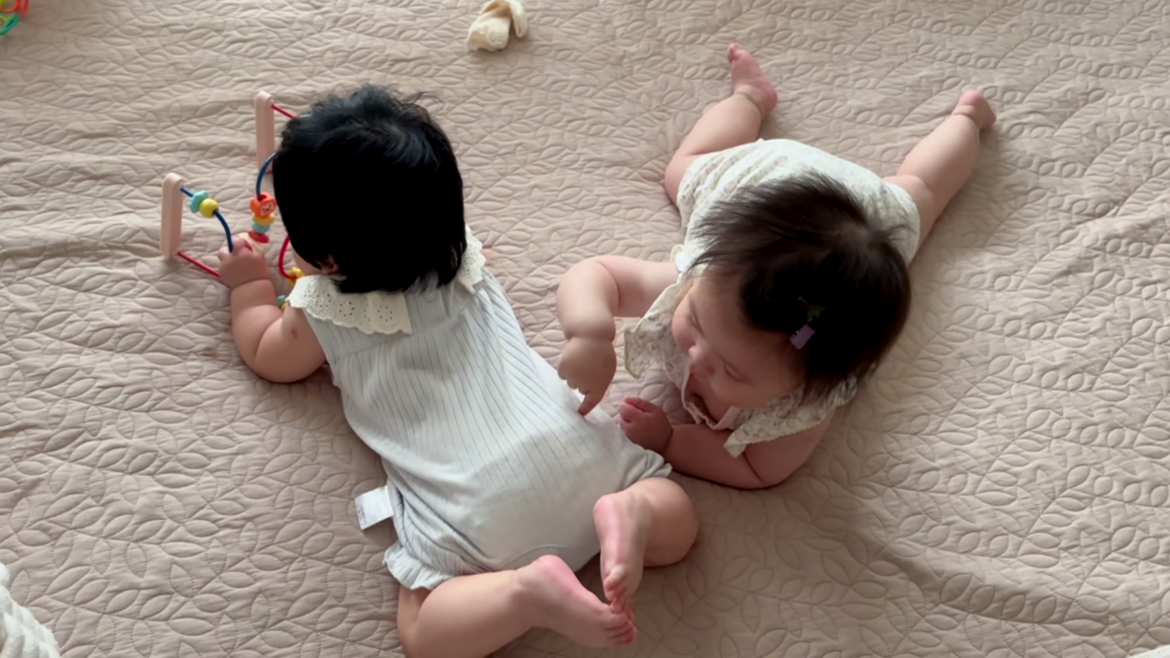 Video thumbnail for Baby Playfully Tries to Nibble Sibling’s Foot in Zhejiang