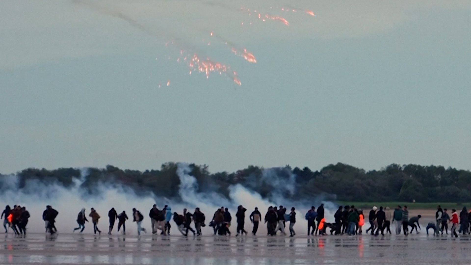 Video thumbnail for French police fire tear gas at migrants on beach