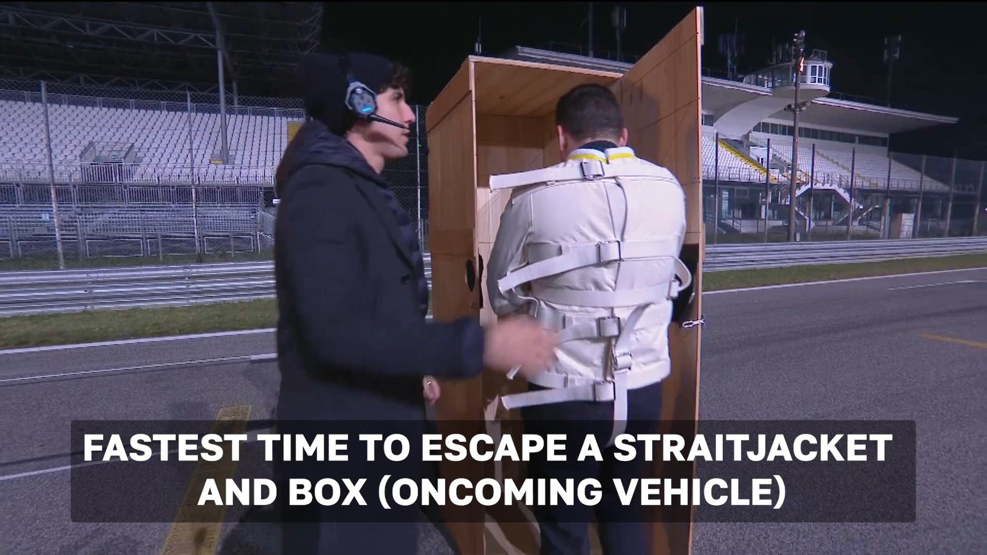 'Video thumbnail for Fastest time to escape a straitjacket and box (oncoming vehicle)'