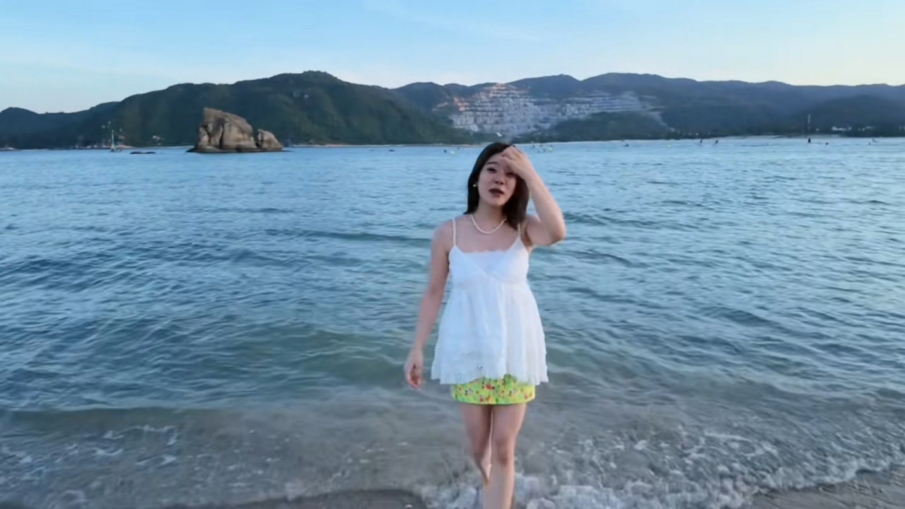 Video thumbnail for Woman Trips and Falls into Water on Shore in Wanning, China