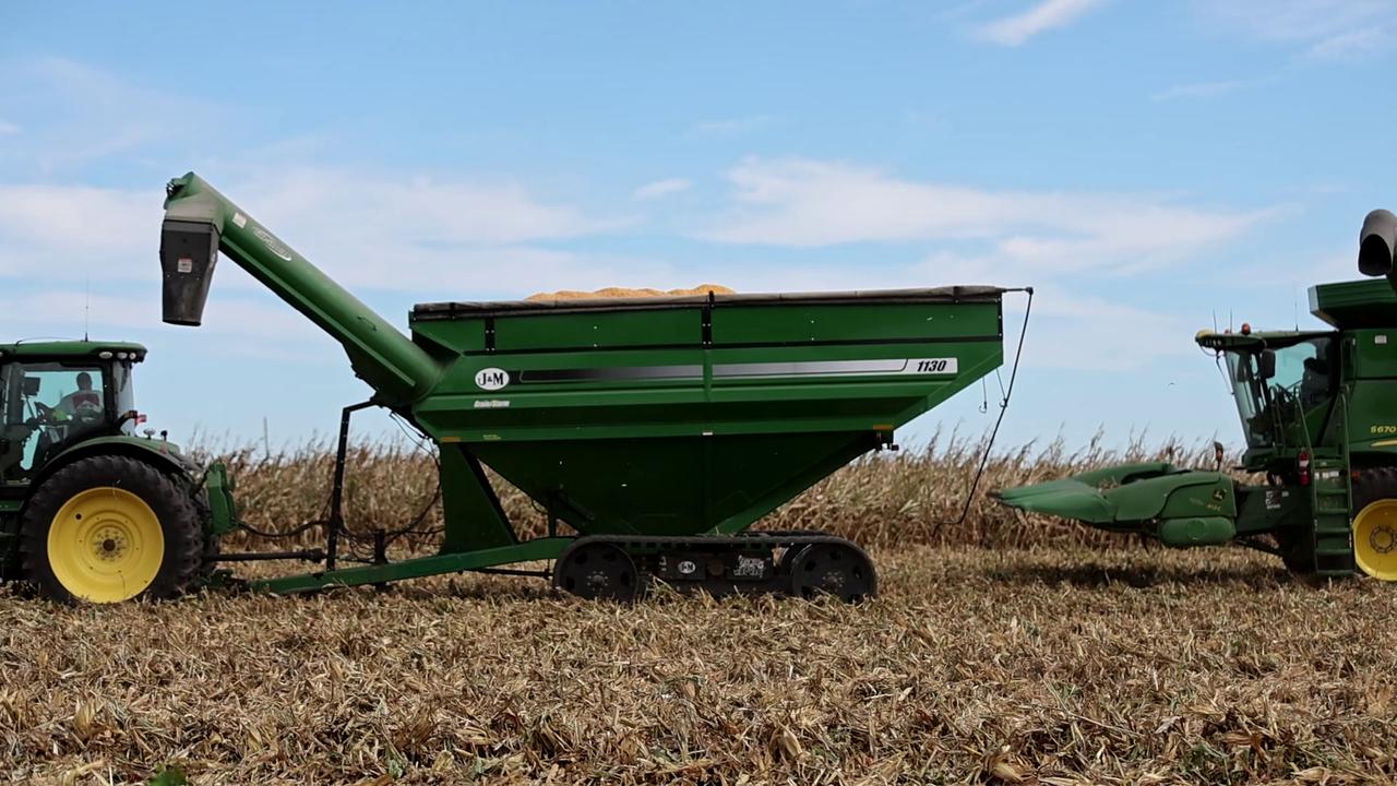 Video thumbnail for US: John Deere S680 Combine Harvester Unloading Grain into Cart During Autumn Harvest.
