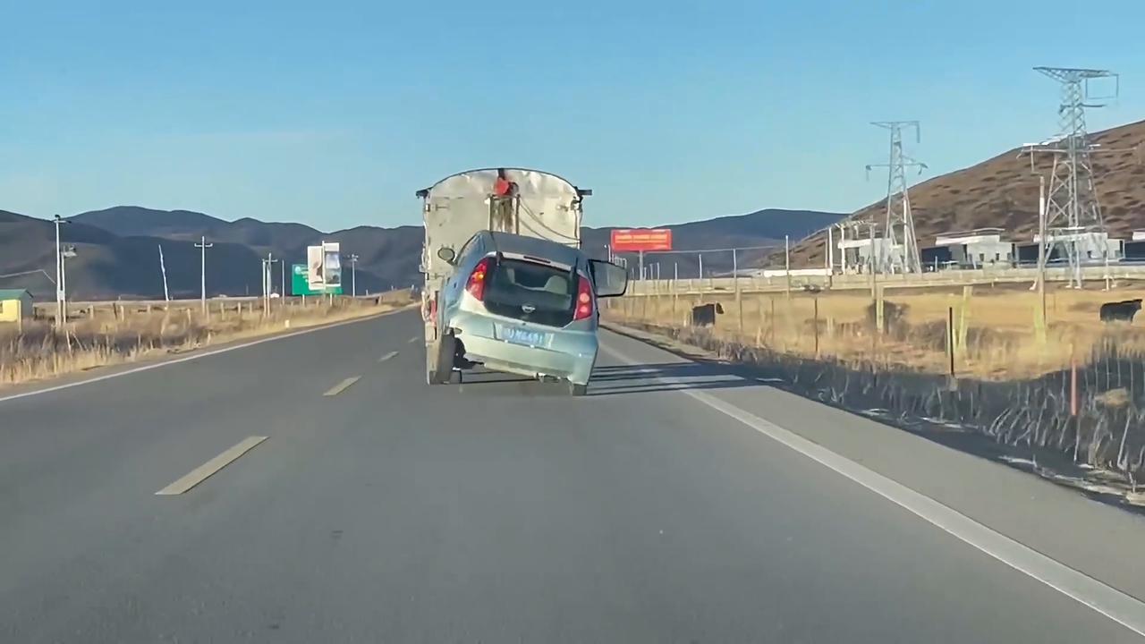 Video thumbnail for China: Broken-down car sways dramatically as it is pulled along road in China.