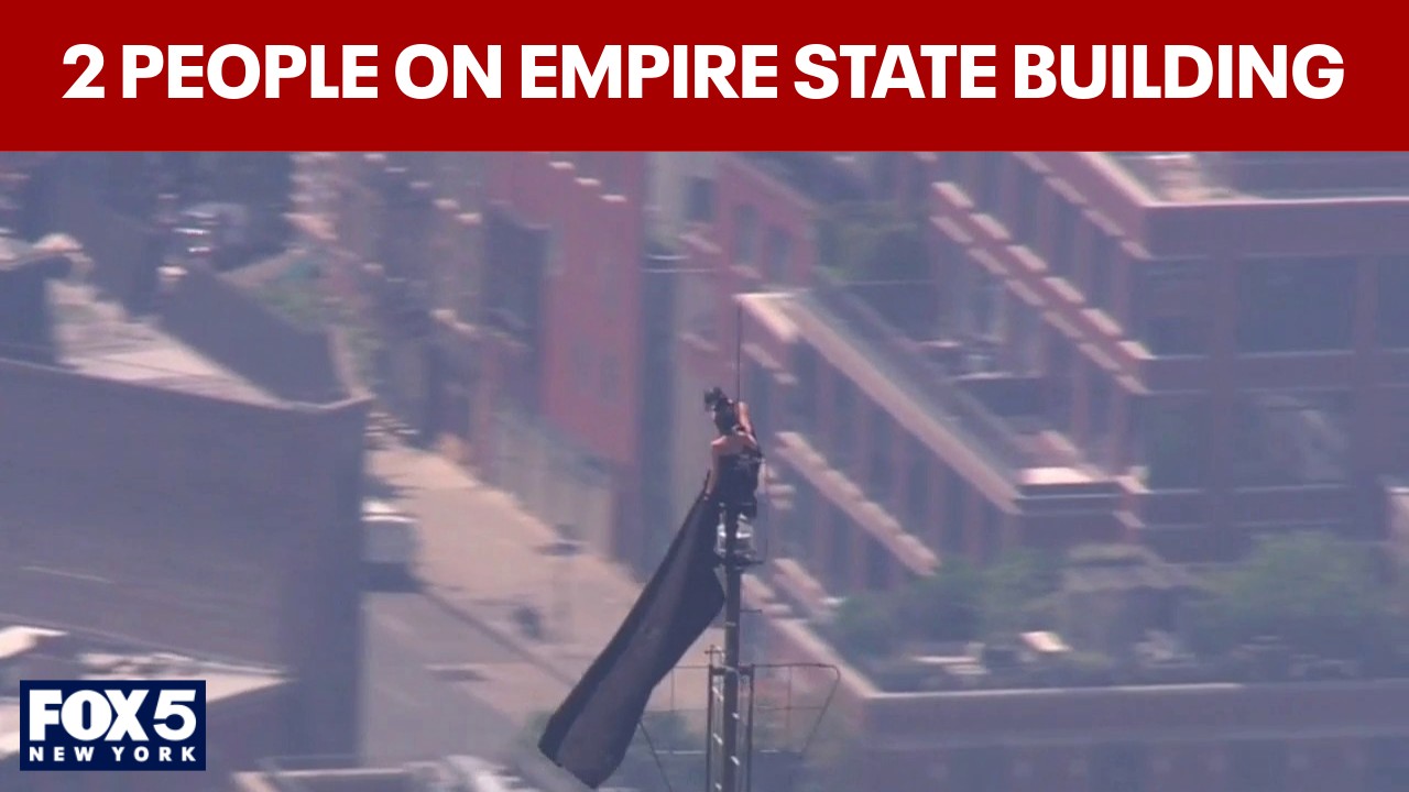 Video thumbnail for WATCH: 2 people climb to top of Empire State Building; raise flag from spire