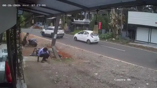 Video thumbnail for India: Security guard narrowly avoids impact as car loses control outside hotel, crashes into electric pole.