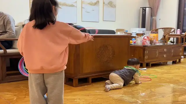 Video thumbnail for Siblings Play Ring Toss Game on the Floor in Shanghai