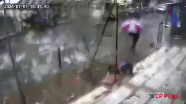 Video thumbnail for India: Heavy rain sends tin sheet flying from roof, woman hit on road.