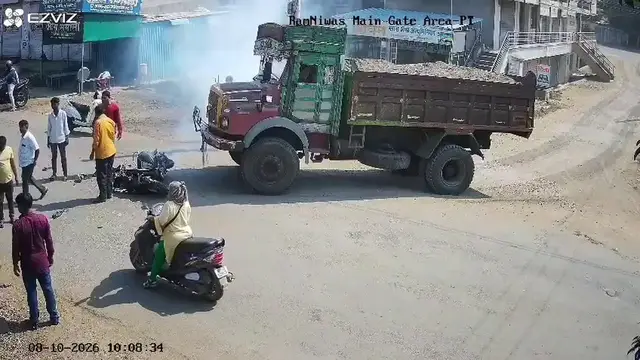 Video thumbnail for India: Scooter-riding woman has a narrow escape after collision with sand-laden tipper truck.