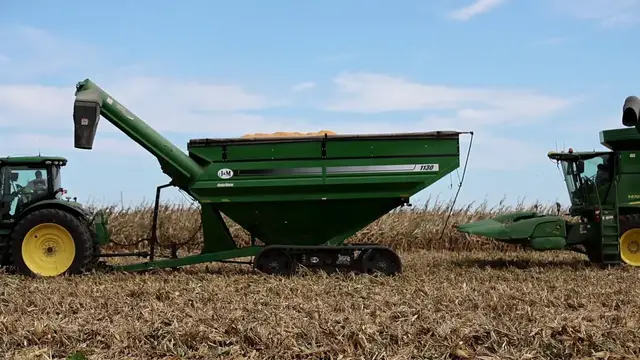 Video thumbnail for US: John Deere S680 Combine Harvester Unloading Grain into Cart During Autumn Harvest.