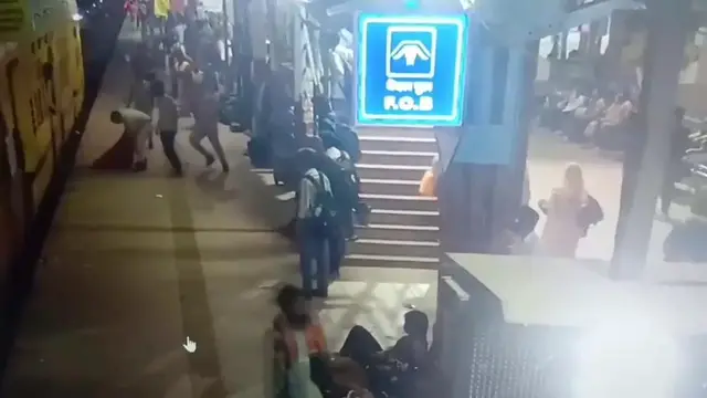 Video thumbnail for India: Official makes split-second rescue as woman nearly falls under moving train at railway station.