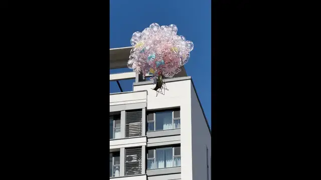 Video thumbnail for Balloons Lift a Chair Above Buildings in Tangshan, China