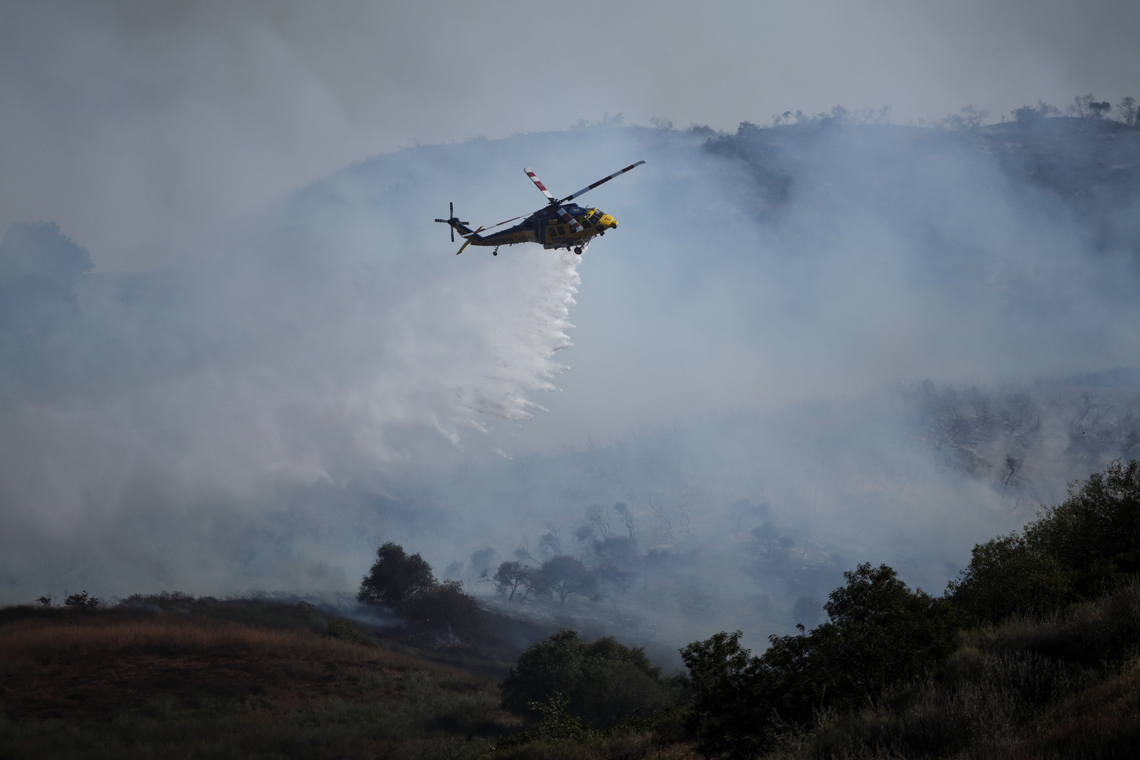 Video thumbnail for Helicopters douse flames threatening hillside homes in California