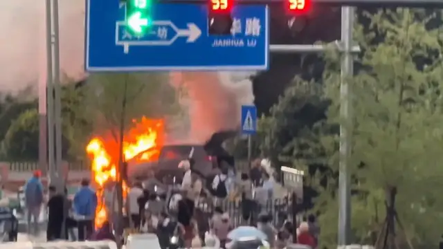 Video thumbnail for China: Car fire sparks panic on road in China as burning SUV blocks traffic.