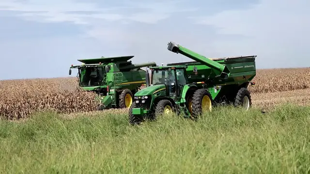 Video thumbnail for US: John Deere Combine Unloading Harvested Corn into Tractor-Drawn Grain Cart.
