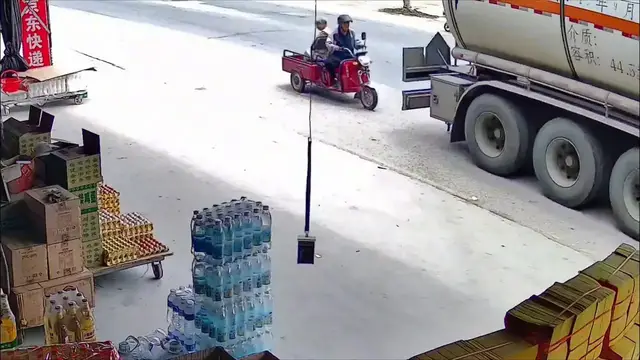 Video thumbnail for China: Chinese shop owner’s warning prevents blind spot collision between truck and elderly rider.