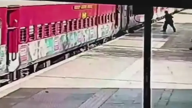 Video thumbnail for India: Passenger trapped between moving train, platform in Delhi as alert official risks life to pull him to safety.