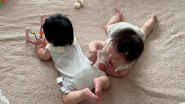 Video thumbnail for Baby Playfully Tries to Nibble Sibling’s Foot in Zhejiang
