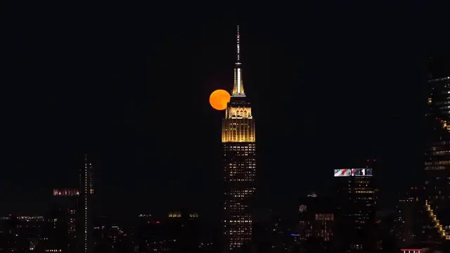 Video thumbnail for US: Strawberry Moon rises behind Manhattan skyline in New York City.