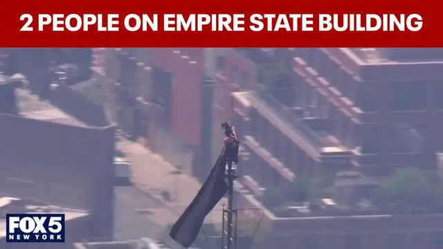 Video thumbnail for WATCH: 2 people climb to top of Empire State Building; raise flag from spire