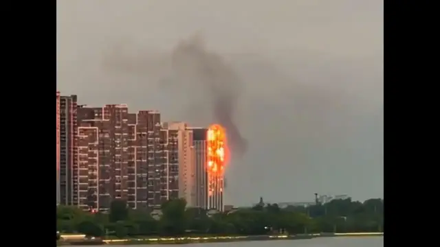 Video thumbnail for China: Building appears engulfed in flames as sunset hits its facade in China.